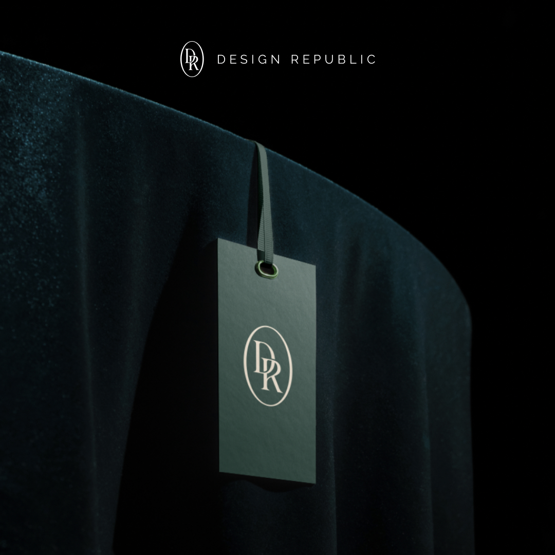 Design As A Subscription 8 A sleek black tag with the DR logo hangs on a luxurious dark green velvet fabric, symbolizing an exclusive design subscription. The text DESIGN REPUBLIC is elegantly displayed above in minimalist style, set against a dark background.